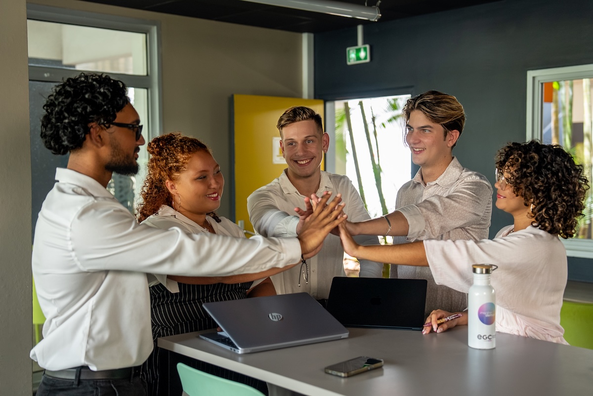 groupe d'étudiants ecole gestion et commerce Réunion se tapant dans la main